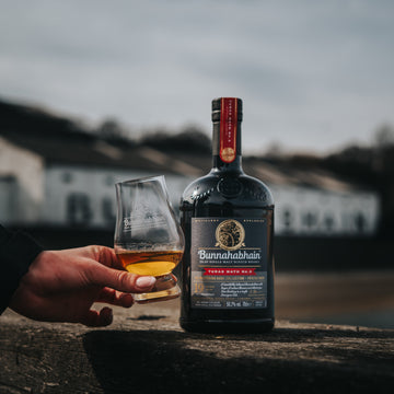 Bunnahabhain Turas Math No.3 sitting on Bunnahabhain Pier with dram in hand